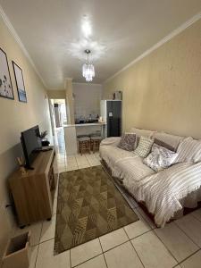 uma sala de estar com uma cama e uma cozinha em Apto 604 vibes em Capão da Canoa