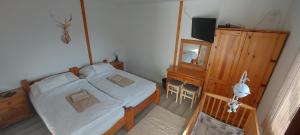 een slaapkamer met een bed, een dressoir en een spiegel bij Gyarmati vendégház in Sirok