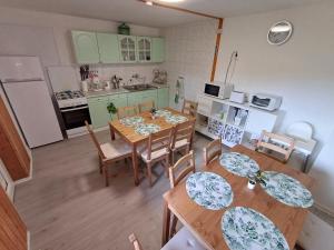 an overhead view of a kitchen with wooden tables and chairs at Gyarmati vendégház in Sirok