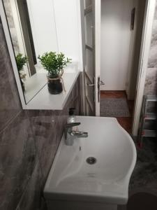 bagno con lavandino bianco e specchio di Apartman Radanović a Foča