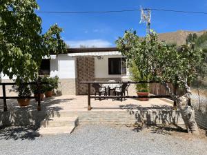 un patio con una mesa de picnic frente a una casa en Cortijo Los Cahorros Sierra Nevada, en Monachil