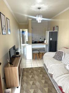 uma sala de estar com uma cama e uma cozinha em Apto 604 vibes em Capão da Canoa
