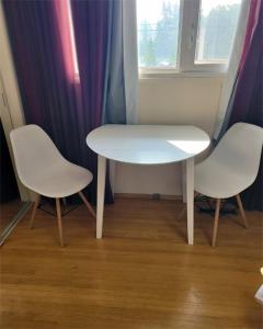 a white table and two chairs in a room at The Dewberry Homestay B&B in Edmonton +13 photos