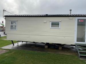 a large white trailer is parked in a yard at Emeralds caravan lettings in Selsey