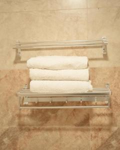 a bunch of towels on a towel rack in a bathroom at Raqeem Hotel in Wadi Musa