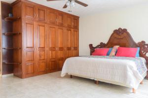 - une chambre avec un grand lit et des placards en bois dans l'établissement Departamento en el Centro de Morelia, à Morelia