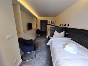 a hotel room with a bed and a chair at 3 Monkeys Hotel in Steinfurt