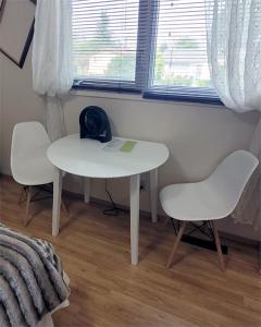 una mesa blanca y 2 sillas en una habitación en The Dewberry Homestay B&B, en Edmonton