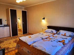 a bedroom with a large bed with butterflies on it at Apartman Lux in Covasna