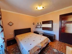 a bedroom with a large bed and a television at Apartman Lux in Covasna +5 photos