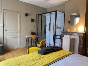um quarto com uma cama e cadeiras amarelas e um frigorífico em Chambre marais em Écourt-Saint-Quentin