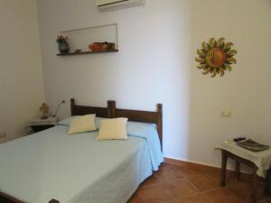 a bedroom with a bed and a mirror on the wall at AltaMarea in Stintino
