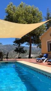 a large swimming pool with a canopy over it at Villa Paloma in Árchez