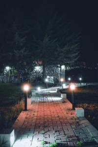a brick walkway with benches and lights at night at Redwalls Lodge in Cajamarca