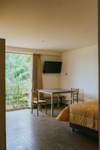 a bedroom with a table and a bed and a window at Redwalls Lodge in Cajamarca