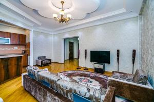 sala de estar con sofá y TV de pantalla plana en Deluxe Apartment 142 en Baku