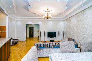 - un salon avec un canapé et une télévision dans l'établissement Deluxe Apartment 142, à Baku