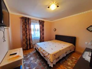 a bedroom with a bed in a room with a window at Apartman Lux in Covasna