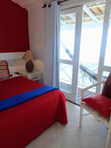 a bedroom with a bed and a chair and a window at Porto Mar de Búzios in Búzios