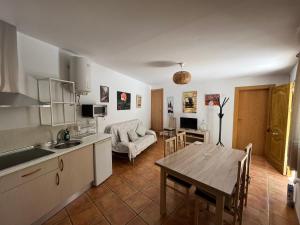 cocina y sala de estar con mesa, cocina y comedor en Cortijo Los Cahorros Sierra Nevada, en Monachil
