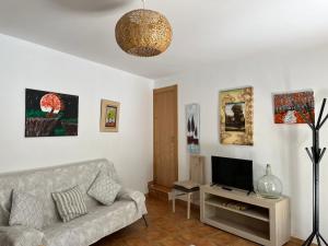 - un salon avec un canapé et une télévision dans l'établissement Cortijo Los Cahorros Sierra Nevada, à Monachil
