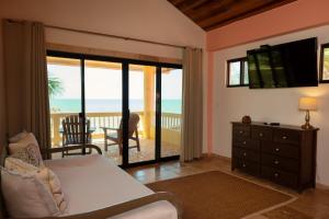 1 dormitorio con cama y vistas al océano en Mission Bay, en Maya Beach