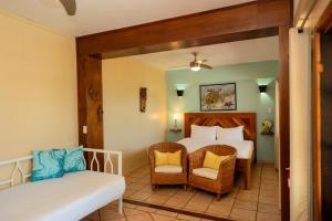 1 dormitorio con 1 cama, 1 sofá y 1 silla en Mission Bay, en Maya Beach