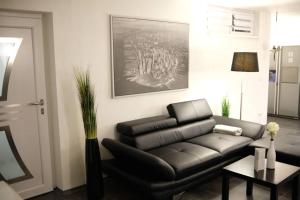 a living room with a leather couch and a table at Bello Apartamento in Graben-Neudorf