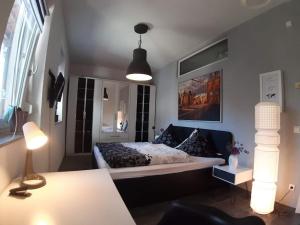 a bedroom with a bed and a couch in it at Bello Apartamento in Graben-Neudorf