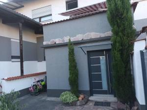 a house with a door and two trees in front of it at Bello Apartamento in Graben-Neudorf