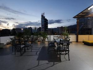 a patio with tables and chairs on a roof at Domani Hotel Boutique in Cochabamba