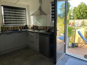 uma cozinha com armários brancos e uma porta de vidro deslizante em Le Cube em Marans