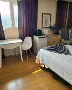 a bedroom with a bed and a desk and a table at The Dewberry Homestay B&B in Edmonton