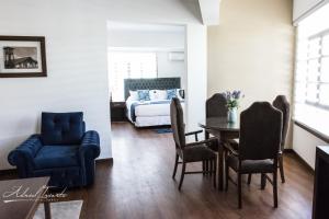 ein Wohnzimmer mit einem Bett, einem Tisch und Stühlen in der Unterkunft Domani Hotel Boutique in Cochabamba