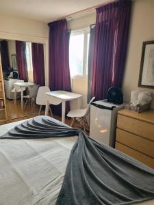 a room with a bed and a table and chairs at The Dewberry Homestay B&B in Edmonton