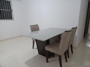 una mesa blanca y sillas en una habitación en Aluga-se quarto em apartamento, en Ipatinga