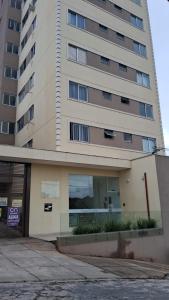 a tall building with a sign in front of it at Aluga-se quarto em apartamento in Ipatinga