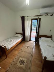 two beds in a room with a window at Guesthouse Space in Përmet