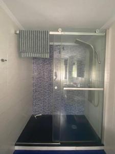 a shower with a glass door in a bathroom at Apartado y cerca de todo in Cotorrio