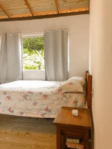 a small bedroom with a bed and a window at Apto 1030 in Trancoso