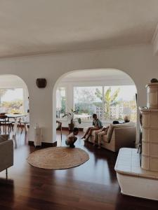 a woman sitting on a couch in a living room at Casa Las Colinas- Preciosa Villa Isleña in La Orotava