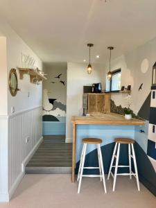 a kitchen with a counter and stools in a room at Mevagissey Boutique Flatlet with sea and countryside views in Mevagissey