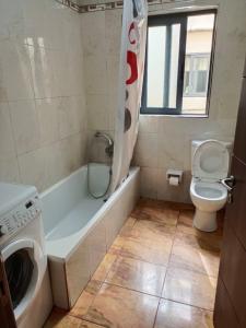 a bathroom with a washing machine and a toilet at you can enjoy your time at waterford apartment in Attard
