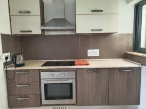 a kitchen with wooden cabinets and a stove top oven at you can enjoy your time at waterford apartment in Attard