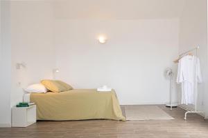 biały pokój z łóżkiem i białą ścianą w obiekcie Irama Suite w mieście Las Puntas