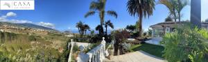 a house with palm trees and a white fence at Casa Las Colinas- Preciosa Villa Isleña in La Orotava +32 photos