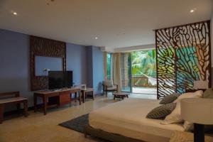 a bedroom with a bed and a tv and a desk at Castillete in Cartagena de Indias