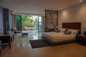 a bedroom with a bed and a desk and a balcony at Castillete in Cartagena de Indias