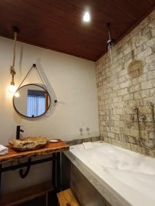 y baño con bañera y espejo. en Vista do Vale lofts - Itaipava, en Petrópolis