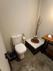 a bathroom with a toilet and a table with a plant at Vista do Vale lofts - Itaipava in Petrópolis